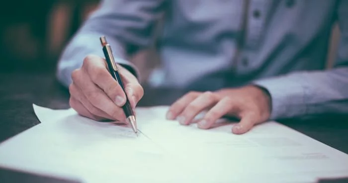A person carefully comparing Will Writing Services Leicester options on a clipboard or laptop